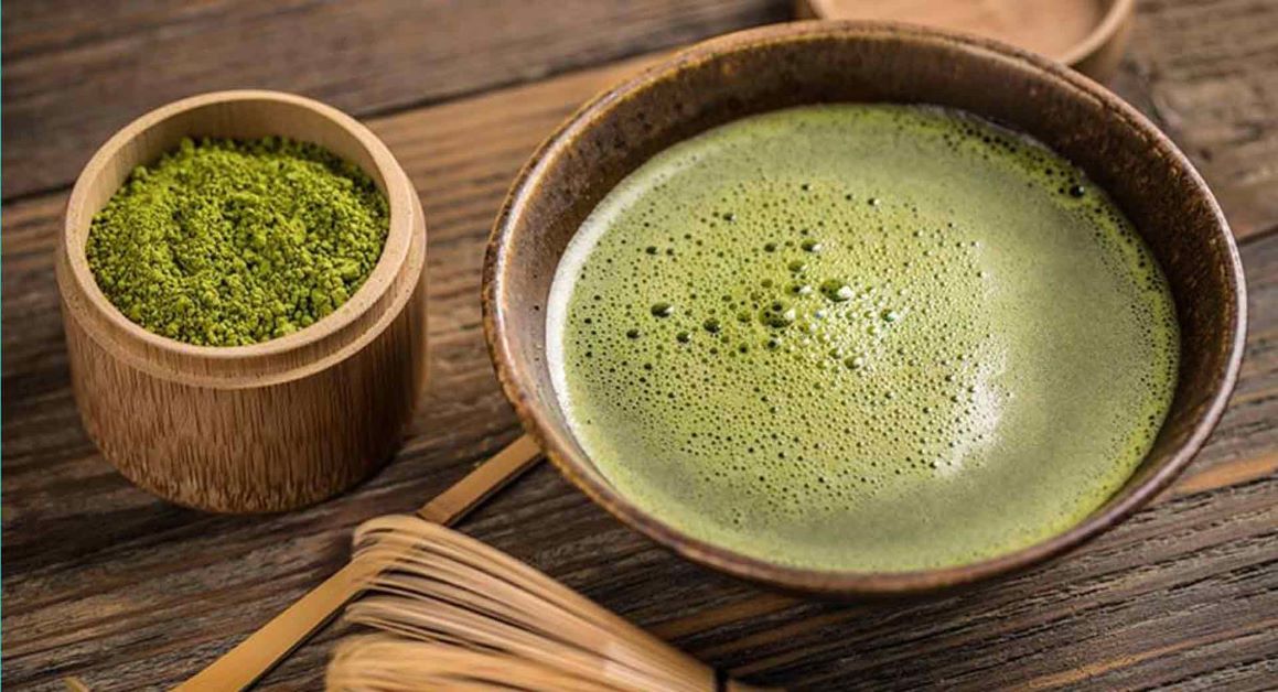 Cup of vibrant green ceremonial matcha tea with bamboo whisk, highlighting antioxidant-rich EGCG catechins and L-theanine